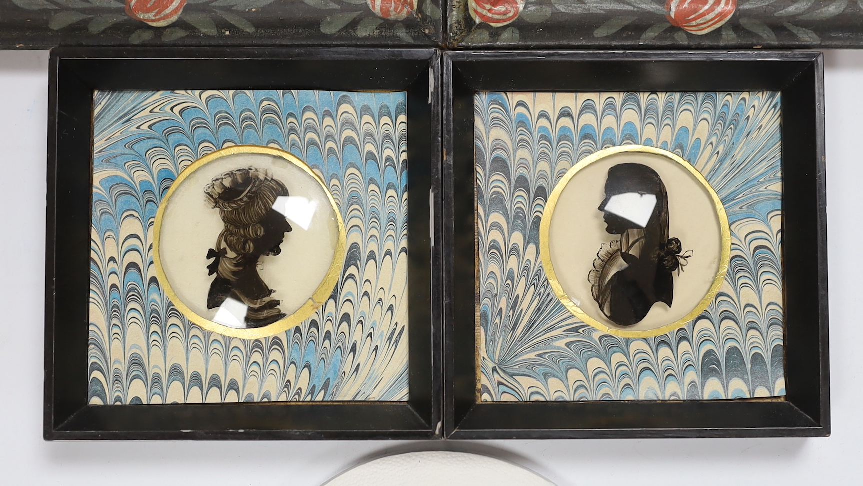 A pair of small reverse painted glass silhouettes, a pair of reverse painted glass panels of St Joseph and St Matheus and an oval plaster relief profile of a Regency gentleman, reverse paintings 14.5cm high x 9.5cm wide